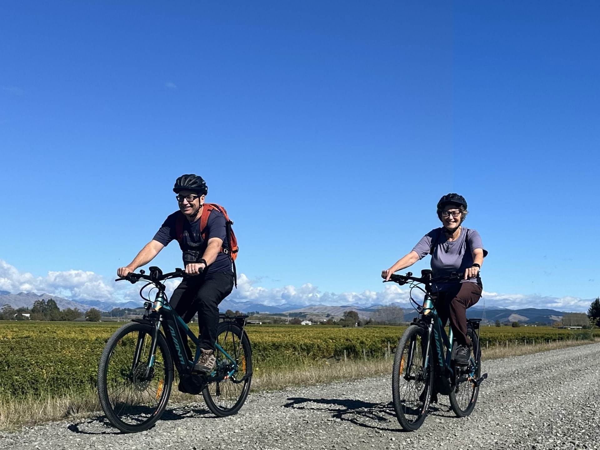 Two cyclists Riding along the stop back gravel road overlooking the vines