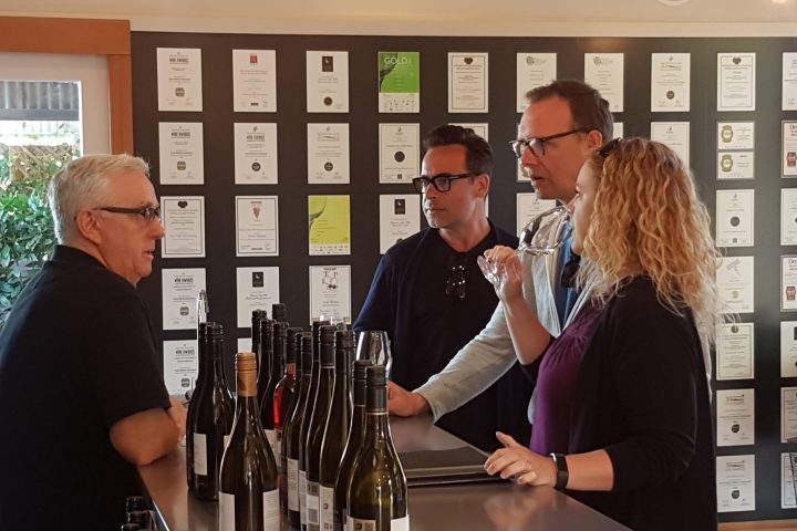 a group of people standing around a table with wine glasses