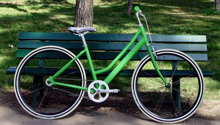 swabdesign_official-1423669-unsplash a bicycle parked in front of a green park bench sitting in the grass