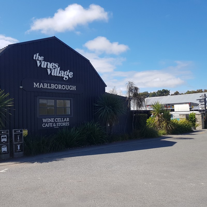 The Vines Village building with signs for wine cellar, cafe, stores in Marlborough.