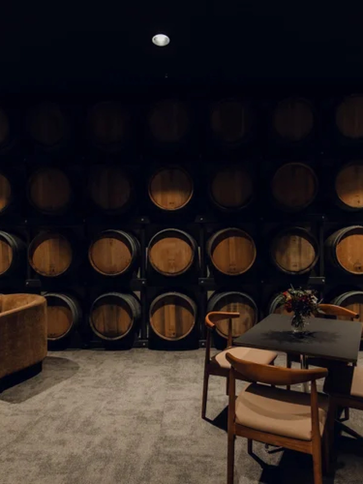 Room with circular wooden barrels on the wall and modern seating area.