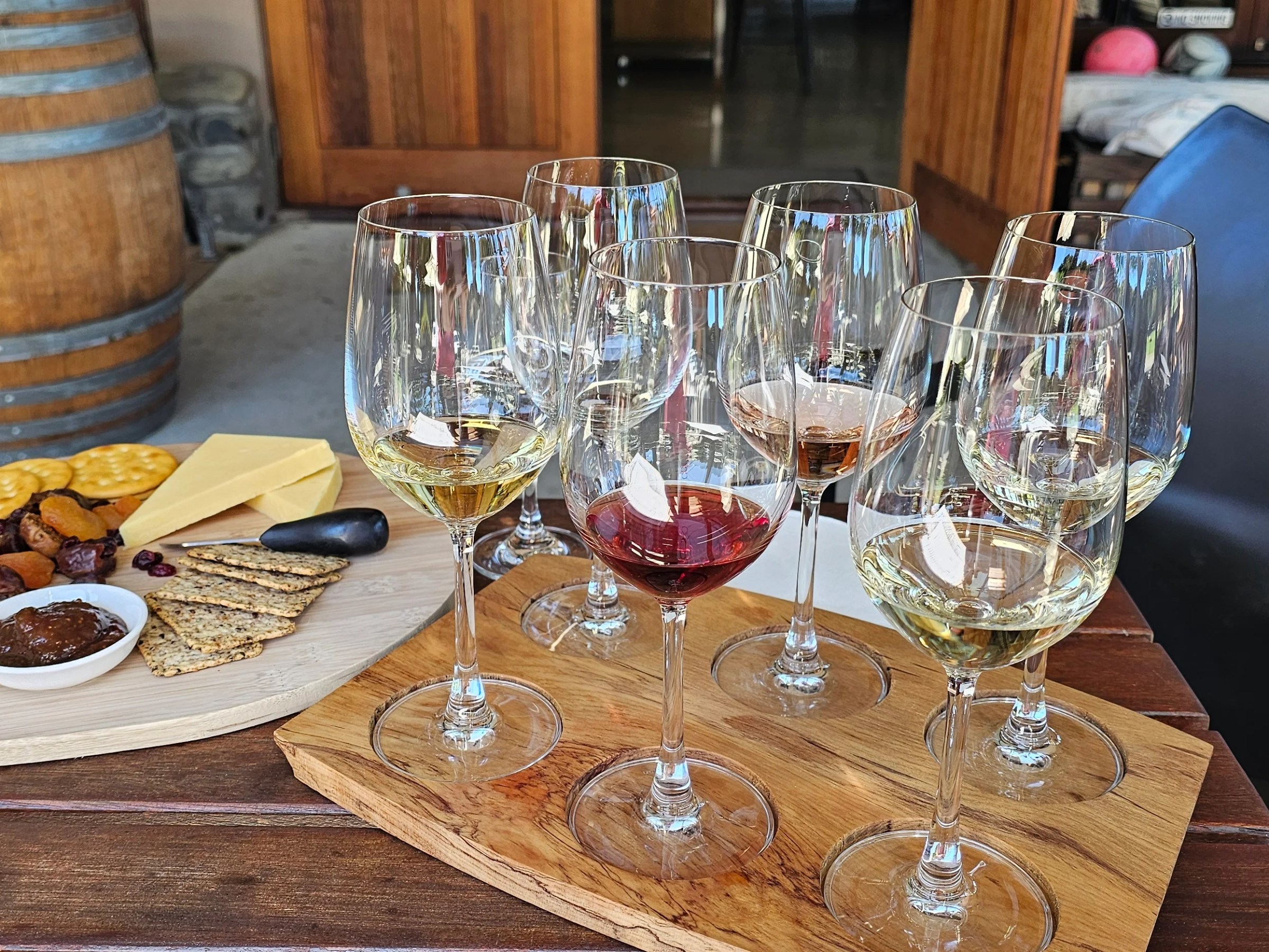 Wine glasses and cheese platter on a wooden table.