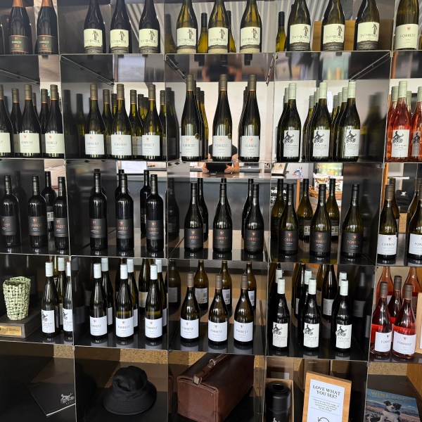A shelf displaying various bottles of wine with some labels visible.
